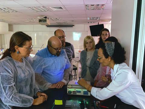 Teachers observing the result of an electrophoresis procedure.